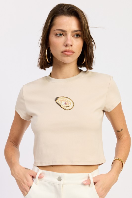 Meet the Oyster Embroidered Baby Tee, a modern essential designed for effortless everyday styling. This cropped baby tee blends clean lines with subtle coastal charm, making it a standout staple in any trend-forward wardrobe. Available in versatile oat and rich brown, this fitted tee transitions seamlessly from casual daytime looks to elevated off-duty outfits.