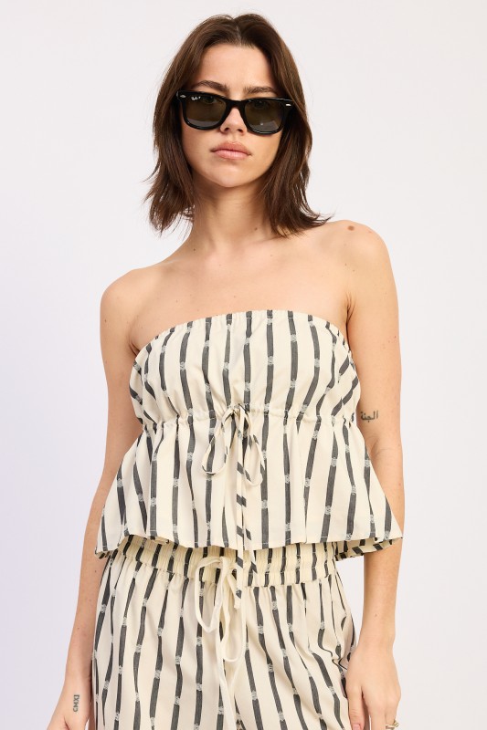 Woman wearing cream and black striped strapless peplum tube top