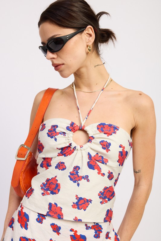 Woman wearing off white floral halter bustier top with matching mini skirt