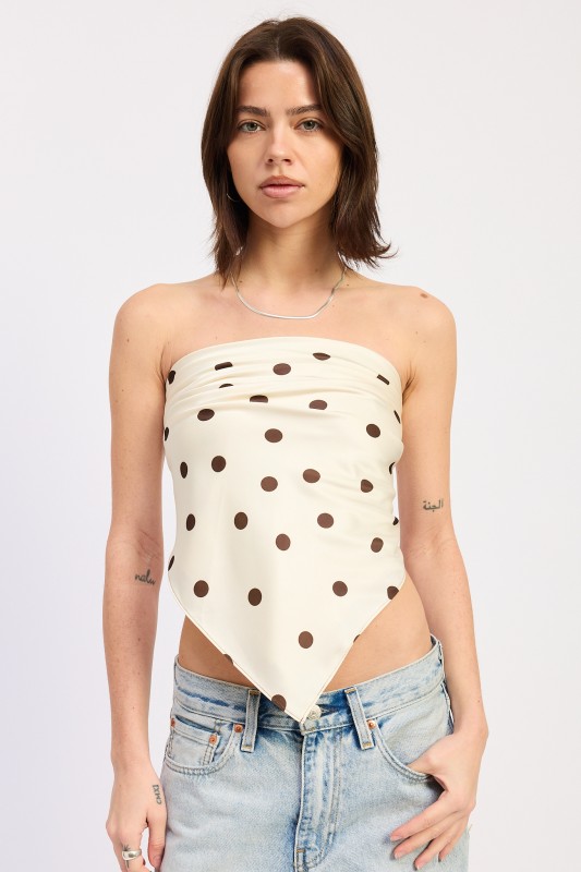 Woman wearing cream polka dot scarf top with light wash jeans