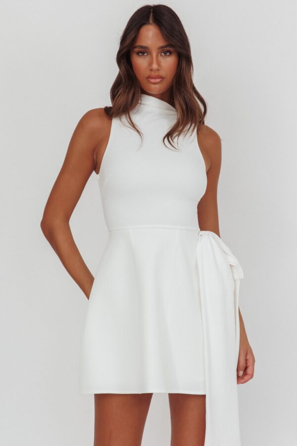 Trendy white sleeveless mini dress with structured silhouette and feminine bow accent