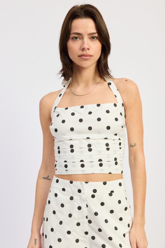 Woman wearing a white polka dot halter crop top with square neckline and matching shorts for trendy summer outfits