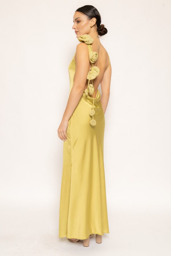 Side view of olive green satin open back maxi dress with rosette accents.