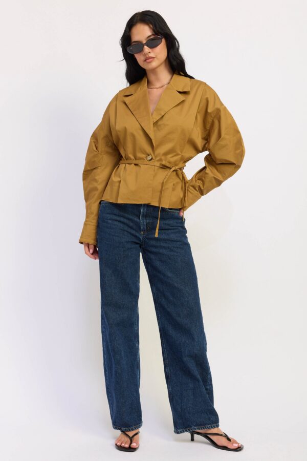Khaki jacket with a V-neckline, front buttons, and long sleeves styled for a women’s boutique fashion look