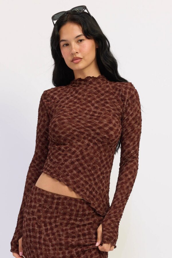Model wearing espresso brown asymmetrical long sleeve top; an asymmetrical silhouette and long sleeves